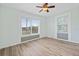 Bright bedroom showcasing wood-look floors, two windows, and fresh neutral paint, creating a serene atmosphere at 511 Sharon Cir, Port Charlotte, FL 33952