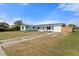 The exterior of a light blue house, with fresh landscaping, a well-manicured lawn, and a long driveway at 511 Sharon Cir, Port Charlotte, FL 33952