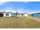 Inviting light blue home showcasing fresh landscaping, a well-manicured lawn, and a modern metal roof at 511 Sharon Cir, Port Charlotte, FL 33952