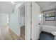 Hallway with wood-look floors, bathroom access, and convenient flow into adjacent bedroom at 511 Sharon Cir, Port Charlotte, FL 33952