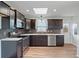Modern kitchen featuring dark cabinetry, stainless steel appliances, a skylight, and stylish backsplash at 511 Sharon Cir, Port Charlotte, FL 33952