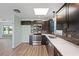 Well-lit kitchen featuring dark cabinets, stainless steel appliances, white marble countertops, and vinyl floors at 511 Sharon Cir, Port Charlotte, FL 33952