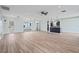 Inviting living room with wood-look flooring, modern lighting, and seamless flow to the adjacent kitchen at 511 Sharon Cir, Port Charlotte, FL 33952