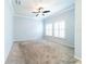 Bright living room with carpet flooring, ceiling fan, and plantation shutters at 20227 Autumn Fern Ave, Tampa, FL 33647