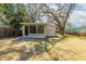 The back yard features an enclosed sun room attached to the house, mature trees and vegetation at 2634 E 38Th Ave, Tampa, FL 33610