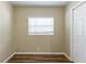 Empty bedroom with a window, closet, and wood-look flooring at 2634 E 38Th Ave, Tampa, FL 33610