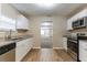 Open kitchen featuring stainless appliances, wood-look floors, and granite countertops at 2634 E 38Th Ave, Tampa, FL 33610