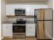 Bright kitchen featuring stainless steel appliances, granite counters, and white cabinets at 2634 E 38Th Ave, Tampa, FL 33610