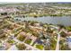Aerial view of a neighborhood highlighting single-Gathering homes with backyard pools near a scenic lake at 6731 Ranger Dr, Tampa, FL 33615