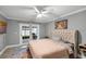 Bedroom with a tufted headboard, ceiling fan, sliding glass doors, and colorful area rug at 6731 Ranger Dr, Tampa, FL 33615