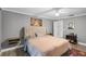 Spacious bedroom with neutral gray walls, a tufted headboard and a colorful area rug at 6731 Ranger Dr, Tampa, FL 33615