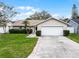Charming single-story home featuring a well-manicured lawn, mature landscaping, and an attached two-car garage at 6731 Ranger Dr, Tampa, FL 33615