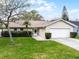 Beautiful single-story house with a lush green lawn, mature landscaping, and an attached two-car garage at 6731 Ranger Dr, Tampa, FL 33615