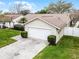 A well-maintained home with a tidy front lawn, groomed shrubs, a paved driveway, and a two-car garage at 6731 Ranger Dr, Tampa, FL 33615