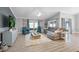 Spacious living room featuring wood floors, neutral decor, and abundant natural light from sliding glass doors at 6731 Ranger Dr, Tampa, FL 33615