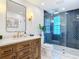 Stylish bathroom featuring a wood vanity, marble countertop, and a glass-enclosed shower at 7525 Sundial Ter, Sarasota, FL 34231