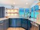 Modern kitchen with blue cabinets, stainless steel appliances, and lots of natural light at 7525 Sundial Ter, Sarasota, FL 34231
