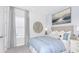 Cozy bedroom featuring a comfortable bed with soft blue bedding, neutral decor, and natural light from a large window at 11120 Wicker Park Pl, Palmetto, FL 34221