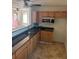 Well-lit kitchen with granite countertops and wood cabinetry, offering functional space and potential at 1827 2Nd E Ave, Bradenton, FL 34208
