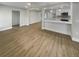 Open-concept living room with wood-look flooring and seamless access to the adjacent modern kitchen at 2642 49Th N St, St Petersburg, FL 33710