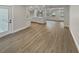 Spacious living room featuring wood-look floors, modern lighting, and seamless flow to the kitchen at 2642 49Th N St, St Petersburg, FL 33710