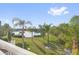 Beautiful backyard featuring a lush lawn, serene lake view, and swaying palm trees at 4324 Spinnaker Cove Ln, Tampa, FL 33615