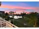 Scenic backyard view with palm trees, lush green grass, and a tranquil lake under a colorful sunset sky at 4324 Spinnaker Cove Ln, Tampa, FL 33615