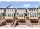 Townhome exterior featuring a three-story facade, drive-in garages, and private entrances at 4324 Spinnaker Cove Ln, Tampa, FL 33615