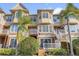 Exterior view of the back of the townhome with a patio, balcony and some tropical landscaping at 4324 Spinnaker Cove Ln, Tampa, FL 33615