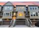 Townhomes with garages, stairs, and beige and gray color palette glow against a colorful sunset sky at 4324 Spinnaker Cove Ln, Tampa, FL 33615