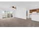 Bright living room with ceiling fan, carpet, and a sliding glass door leading to a small balcony at 4324 Spinnaker Cove Ln, Tampa, FL 33615