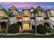 Rear view of townhomes with palm trees and a lush green lawn with private patios and white railings at 4324 Spinnaker Cove Ln, Tampa, FL 33615