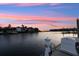 Waterfront view with a dock, boat fueling station, and serene lake under a colorful sky at 4324 Spinnaker Cove Ln, Tampa, FL 33615