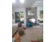Bright living room featuring a stone fireplace, large windows, and comfortable seating at 4375 Neff Lake Road, Brooksville, FL 34601