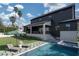 Beautiful backyard featuring a pool, lounge chairs, manicured lawn, and covered patio of the modern home at 1056 Snell Isle Ne Blvd, St Petersburg, FL 33704