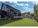 Expansive backyard features a covered patio, manicured lawn, and lounge seating of the modern home at 1056 Snell Isle Ne Blvd, St Petersburg, FL 33704