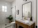 Bright bathroom featuring a glass enclosed shower with neutral toned tile and rustic vanity with modern fixtures at 1056 Snell Isle Ne Blvd, St Petersburg, FL 33704