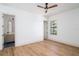 Bright bedroom features hardwood floors, a ceiling fan, and an attached bathroom with modern fixtures at 1056 Snell Isle Ne Blvd, St Petersburg, FL 33704