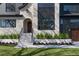 Close-up of home's facade showcases stone and dark siding, arched doorway, and well-manicured landscaping at 1056 Snell Isle Ne Blvd, St Petersburg, FL 33704