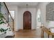 Inviting foyer featuring a wood door, staircase, wooden floors, and archway at 1056 Snell Isle Ne Blvd, St Petersburg, FL 33704