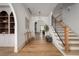Elegant foyer with arched doorways, hardwood floors, staircase, and custom shelving at 1056 Snell Isle Ne Blvd, St Petersburg, FL 33704