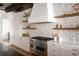 Well-equipped kitchen featuring stainless steel appliances, floating shelves, and stone accent wall at 1056 Snell Isle Ne Blvd, St Petersburg, FL 33704