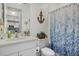 Bathroom features a vanity sink, toilet, blue shower curtain, and nautical decor at 5819 Mezzana Run, Palmetto, FL 34221