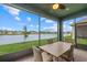 Covered patio with seating overlooking lush backyard and picturesque lake view at 5819 Mezzana Run, Palmetto, FL 34221