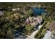 Expansive waterfront property showcasing a well-manicured lawn, mature trees, and circular driveway at 7705 Weeping Willow Cir, Sarasota, FL 34241