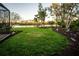 Landscaped backyard with manicured lawn and peaceful pond views at 7705 Weeping Willow Cir, Sarasota, FL 34241