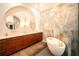 Bright bathroom with dual vanities, soaking tub, chandelier and elegant marble accents at 7705 Weeping Willow Cir, Sarasota, FL 34241