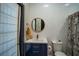 Stylish bathroom featuring a modern vanity, round mirror, and a patterned shower curtain at 7705 Weeping Willow Cir, Sarasota, FL 34241