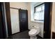 Modern bathroom featuring a sliding barn door, comfort height toilet, and a window at 7705 Weeping Willow Cir, Sarasota, FL 34241