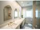 Elegant bathroom featuring double sinks, marble countertops, decorative mirrors, and a separate shower at 7705 Weeping Willow Cir, Sarasota, FL 34241